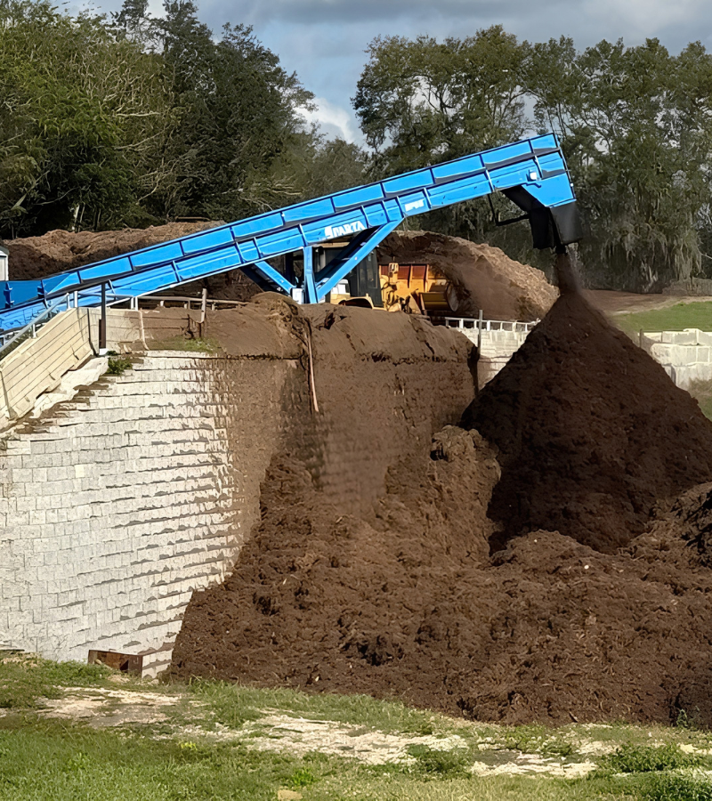 Sparta conveyor stacking processed organic material at a composting facility.